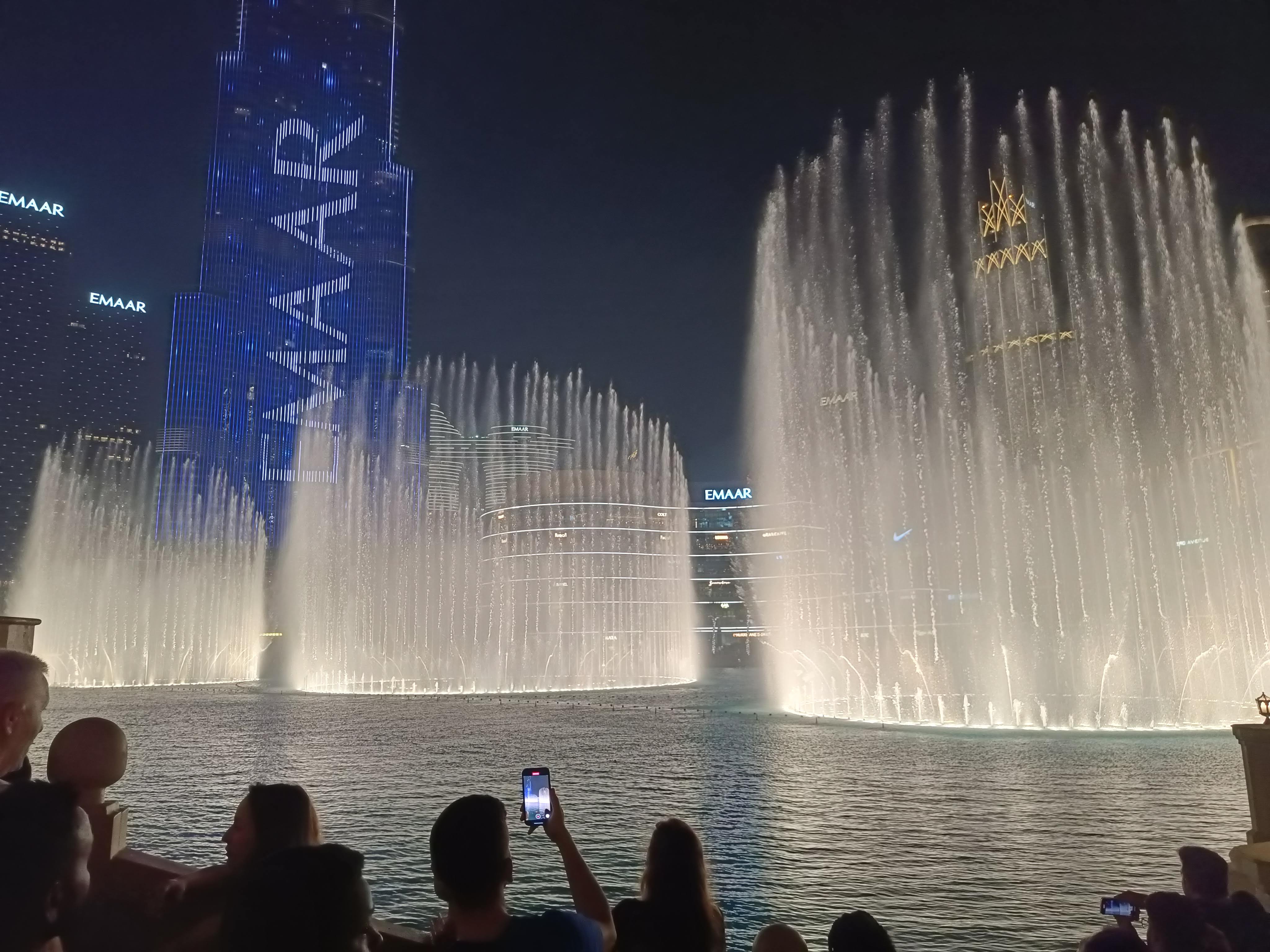 Dubai Fountain show against backdrop of Burj Khalifa at night - spectacular free attraction at Dubai Mall